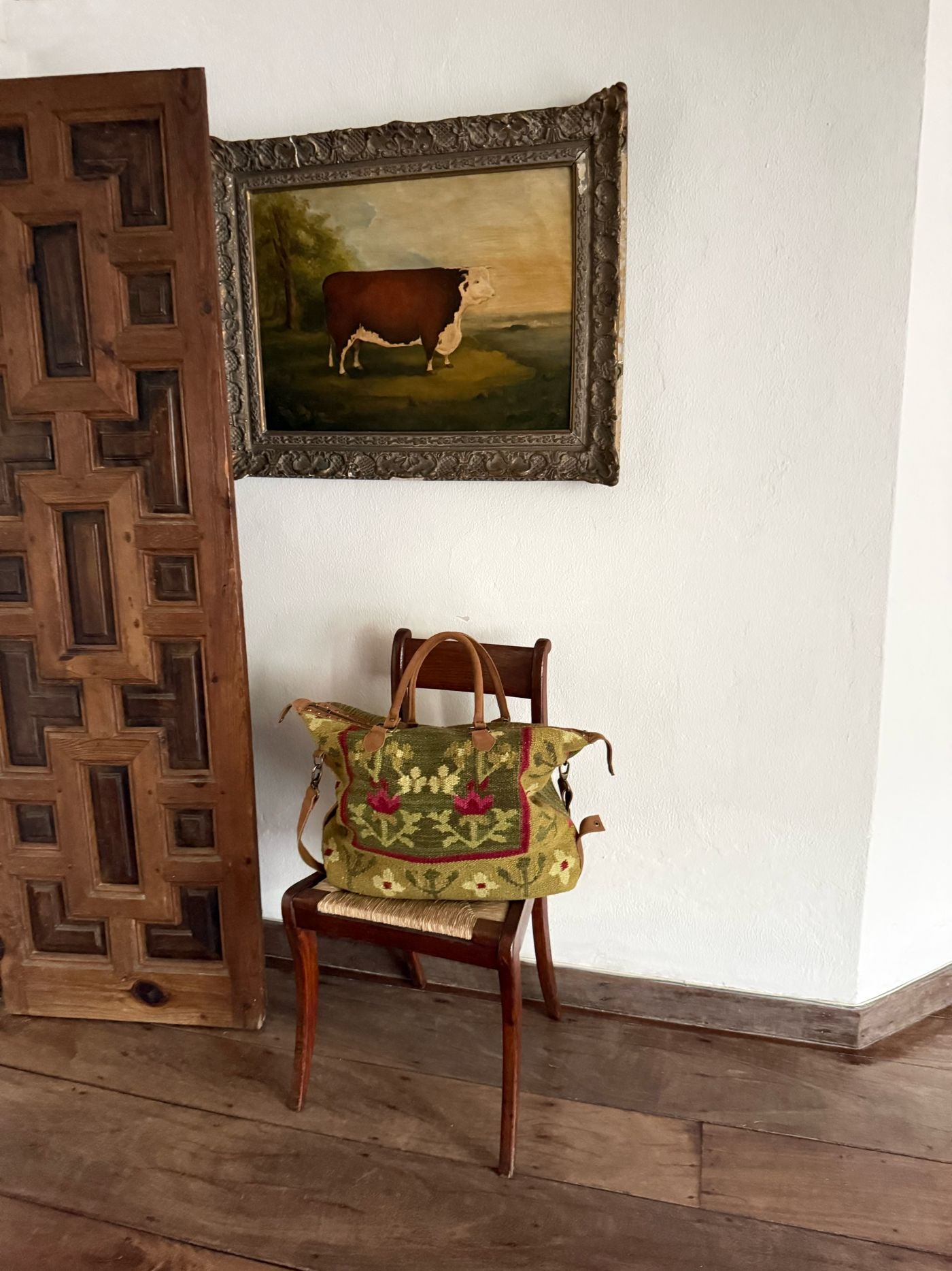 Bolsa de viaje de kilim junto a una puerta de madera
