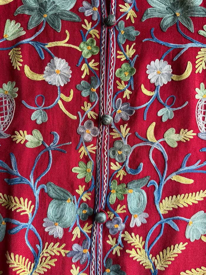 Detalle de bordado floral sobre lana roja
